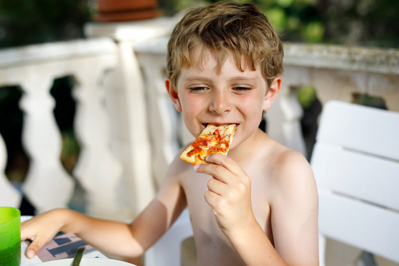 Un enfant mange une pizza